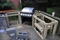 an outdoor grill built into the side of a house with wood pallets around it