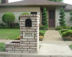 a brick mailbox in front of a house