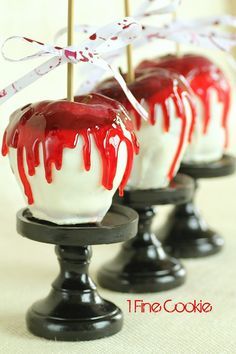 some kind of dessert with red and white toppings on top of black pedestals