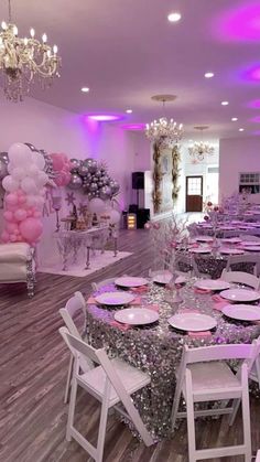 a room filled with tables and chairs covered in pink and white balloons, plates and silverware