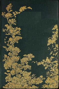 an old book with gold flowers and leaves on green paper in front of a black background