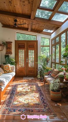 a sun room filled with lots of windows and plants on the floor next to a couch