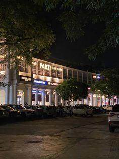 cars parked in front of a building at night