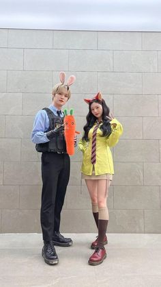 two people dressed in costumes standing next to each other with carrots on their heads