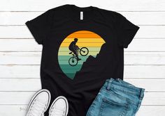 You Will Love this Unique and Cool Mountain Biker T-shirt. Makes A Great Gift For Mountain Bikers! Please refer to the listing pictures for the size guide and other color options. * Bella-Canvas Short Sleeve Unisex T-Shirt * Design is printed on One side * 100% combed and ring-spun cotton (Heather colors contain polyester) * Fabric weight: 4.2 oz./yd.² (142 g/m²) * Pre-shrunk fabric * Side-seamed construction * Shoulder-to-shoulder taping * Design is professionally PRINTED using commercial grade equipment for a long lasting shirt. * Soft and High-Quality Fabric ►► FONTS & DESIGN * Design size and placement is approximate. Each shirt is custom hand made. Exact size & placement of design may vary. * Due to monitor differences, actual colors may vary slightly from what appears online. * Pleas Black Short Sleeve T-shirt For Cycling, Graphic Print Short Sleeve T-shirt For Cycling, Graphic Cycling T-shirt With Crew Neck, Graphic Tee T-shirt With Crew Neck For Cycling, Graphic Tee With Crew Neck For Cycling, Black Biker T-shirt For Outdoor Activities, Sporty Graphic Print T-shirt For Cycling, Black Biker T-shirt For Casual Wear, Biker Shirts