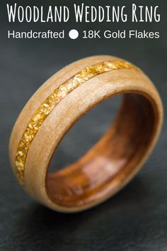 wood wedding ring with gold flakes inlayed to the outside and inside, on a black background