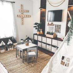 a living room filled with furniture and a teepee tent on top of a rug