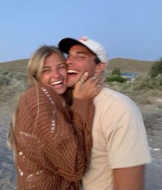 a man and woman are laughing together on the beach