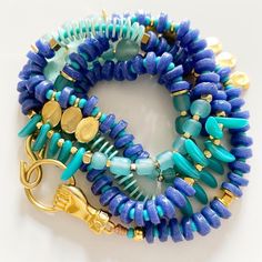 Do you love to explore and go on adventures in the summer? Then you need a versatile and stylish accessory to accompany you every step of the way. Buenaventura necklace/bracelet made with handmade African glass beads in shades of blue/violet and aqua is just what you need. You can wear it as a one or two-loop necklace or as a multi-loop bracelet. Additionally, its fist-shaped closure serves as a lucky charm.  Add a touch of color and originality to your summer look with this must-have accessory! Blue Natural Stones Bracelets For Beach, Blue Natural Stone Bracelets For Beach, Blue Natural Stone Beach Bracelets, Blue Bracelets With Lobster Clasp For Beach, Blue Gemstone Beads Jewelry For Beach, Blue Spiritual Jewelry For Vacation, Blue Bracelet For Vacation, Blue Hand-strung Beach Jewelry, Hand-strung Blue Jewelry For Beach