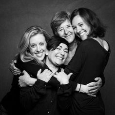 black and white photograph of four women hugging each other