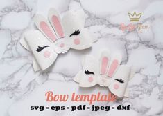 three white bunny ears with pink noses and black eyelashes on top of a marble surface