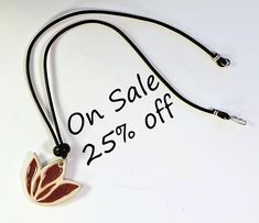 A perfect one-of-a-kind gift for yourself or someone special such as your mother, daughter, grandmother, wife, or friend. Especially for lovers of handmade ceramic jewelry. This elegant hand-crafted ceramic necklace has a glazed porcelain pendant that is 1 1/2"x1 1/2". It is strung on a black leather cord.  The closure is a sterling silver hook and loop.  The necklace is 18" long.  Other materials include a wood bead. This unique jewelry piece is the perfect accessory for daytime or evening wear. The pendant is fired at high temperature for extra strength and durability.    Each pendant is hand made by me using molds I have created or natural textures. Every artisan created piece has differences or imperfections which make it unique.  If you have any questions, please don't hesitate to ask White Waxed Cord Necklace - Perfect Gift, White Waxed Cord Necklace For Gift, Ceramic Pendant Necklace, Handmade Ceramic Jewelry, Ceramic Necklace, Ceramic Pendant, Flower Motif, Ceramic Jewelry, Handmade Ceramic