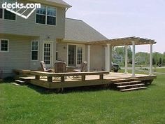 a house with a deck in the front yard and an attached pergolated patio