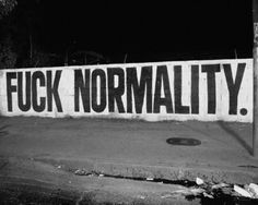 a black and white photo of a street sign that says, f k normality