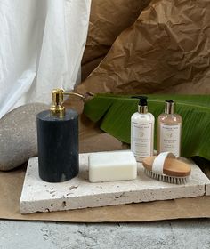 a soap, brush, and lotion sitting on top of a piece of paper