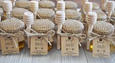 small bottles filled with honey sitting on top of a wooden table covered in burlocks