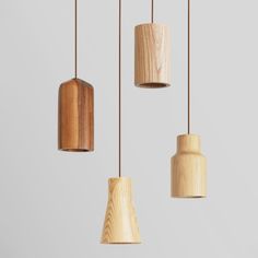 three wooden lights hanging from the ceiling in different shapes and sizes, with one light turned on