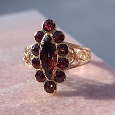 Ring Size: US 10  EU 62 14k gold Natural Almandine Garnet Weight: 3.50 grams Size: 10mm x 20mm Condition: Excellent This ring is a stunning piece of jewelry that showcases the timeless elegance of the Victorian style. It features a floral design made from 14k gold, with multiple garnet stones that sparkle with a deep red hue. The garnets are arranged in a symmetrical pattern, creating a harmonious and balanced look. The ring is polished to perfection, reflecting light beautifully. This ring is a Victorian Style Red 14k Gold Ring, Victorian Garnet Ring Gift, Victorian Garnet Gemstone Rings, Antique Hallmarked Garnet Ring, Victorian Gold Ruby Ring With Multi-stone, Symmetrical Pattern, Handmade Gold Ring, Red Garnet Ring, Almandine Garnet