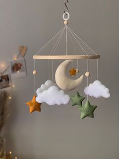 a mobile with stars, moon and clouds hanging from it's sides in a child's room