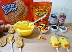 a table topped with cookies, candy and candies next to a bag of peanut butter