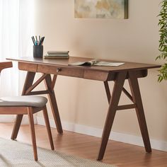 a wooden desk with a chair next to it in front of a painting on the wall