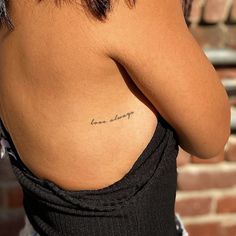 the back of a woman's body with her arm tattoo reading love is always