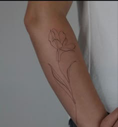 a woman's arm with a flower tattoo on the left side of her arm