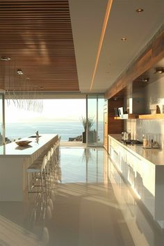 a large kitchen with an island counter top next to the ocean