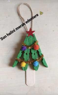 a christmas tree made out of popsicle sticks on a white surface with the words son hain ner engelhere above it