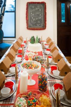 a table is set up for a holiday party with gingerbreads, candy and cookies