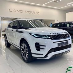 a white range rover parked in a showroom