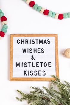 christmas wishes and mistletoe kisses cross stitch pattern in wooden frame on white background