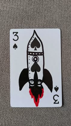 a playing card with an image of a rocket ship on it