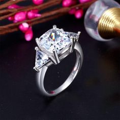 a princess cut diamond engagement ring with two side stones