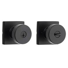 two black knobs on the side of a white wall