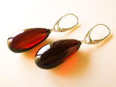 "Natural Baltic amber very dark red long drop shape earrings - best gift for your loved one. These genuine handmade amber earrings are modern and classy at the same time and you can definitely sense the quality. Royal red amber color looks great with most of your outfits and even make them look better! MATERIALS AND SIZE: Stone: 100% Natural Baltic Amber Findings: Sterling silver 925 Weight: 5,9 - 6,0 g (0,20 - 0,21 oz) Bead size: 2,5 - 2,6 cm (0,98 - 1.02 in) x 1,3 - 1,4 cm (0,51 - 0,55 in) Tot Modern Amber Earrings For Formal Events, Modern Amber Earrings For Formal Occasions, Elegant Brown Teardrop Earrings For Gift, Elegant Burgundy Earrings For Formal Occasions, Elegant Baltic Amber Teardrop Jewelry, Elegant Teardrop Baltic Amber Jewelry, Elegant Baltic Amber Dangle Jewelry, Elegant Baltic Amber Teardrop Earrings, Elegant Single Amber Earring