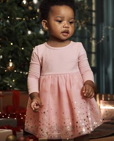 Add a dash of sparkle to festive occasions in this beautiful tulle dress for baby. Machine-washable tulle keeps this dress party-ready all season! • Multi-layered tulle skirt with shimmer detail • Skirt is comfortably lined in combed cotton jersey • Stretch waist • Like new wash after wash • OEKO-TEX® STANDARD 100 certified safe from hundreds of harsh chemicals Body & sleeves are 95% cotton/5% spandex stretch jersey Skirt is recycled polyester tulle & polyester organza Skirt is lined in 100% com Toddler Christmas Dress, Dress For Baby, Organza Skirt, Layered Tulle Skirt, Shimmer Dress, Jersey Skirt, Hanna Andersson, Baby Long Sleeve, Knee Length Skirt