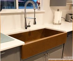 a kitchen sink with a faucet over it and a window in the background