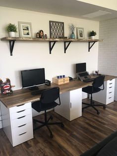 an office with two computer desks and shelves on the wall