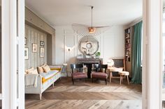 a living room filled with furniture and a fire place next to a dining room table