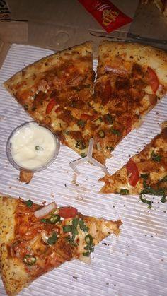 four slices of pizza on top of a white paper with some sauce and other toppings