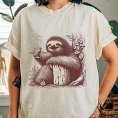 Morning Coffee T-Shirt for Women and Men Funny Sloth Drinking Cup of Coffee Graphic Tee Tops Comfort Colors 🌸 Soft & Lightweight Material - Graphic tees for women are made from a soft, lightweight, and stretchy fabric that provides a familiar and comfortable feel. You'll love wearing it all day long. 🌸 GREAT GIFT:  Good choice as a gift for your mom, sister, your wife or anyone you want to send a gift. The print is a great inspirational message for anti-bullying, positive energy and love peace Coffee Color Graphic Tee With Crew Neck, Coffee Color Crew Neck Top With Screen Print, Coffee Color Crew Neck Top, Coffee Color Crew Neck Shirt With Graphic Print, Coffee Color Crew Neck Graphic Tee, Coffee Graphic Tee With Crew Neck, Coffee Color Crew Neck Top With Funny Print, Coffee Crew Neck Top With Screen Print, Coffee-colored Crew Neck Top With Screen Print