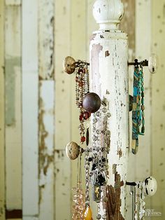 an old white pole with lots of jewelry hanging from it's sides and the words jewelry perch above it