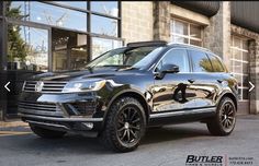 a black suv parked in front of a building