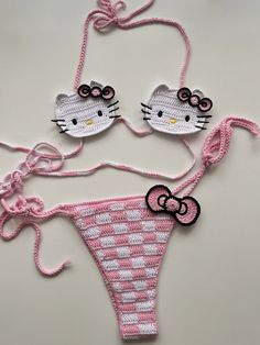 two hello kitty bikinis are shown on a table