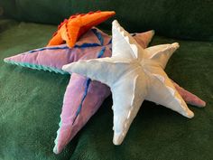 two starfish pillows sitting on top of a green couch