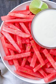 a white plate topped with watermelon wedges and a bowl of ranch dressing