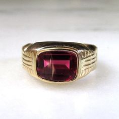 This is a vintage solid 14K yellow gold ring set with a red glass stone.  The band is sized at 8 3/4.  The stone measures 9.38mm x 7.53mm.  Total weight of the ring is 10.2 grams.  The inside of the band is marked 14K with no hallmark. This is a vintage, previously owned ring.  Therefore, light wear can be expected.  There is no visible damage. Antique Red 14k Gold Signet Ring, Antique Red Signet Ring In 14k Gold, Classic Red Signet Ring For Formal Occasions, Vintage Red Hallmarked Signet Ring, Heirloom Red Gold Signet Ring, Classic 14k Gold Red Signet Ring, Classic Red 14k Gold Signet Ring, Antique Ruby Signet Ring For Formal Occasions, Classic Red Signet Ring Stamped 14k