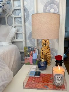 a bedroom with a cheetah lamp, cell phone and other items on the table