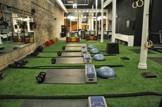 an indoor gym with artificial turf and exercise mats